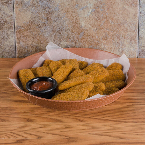 A terracotta plastic basket filled with fried chicken strips and sauce.