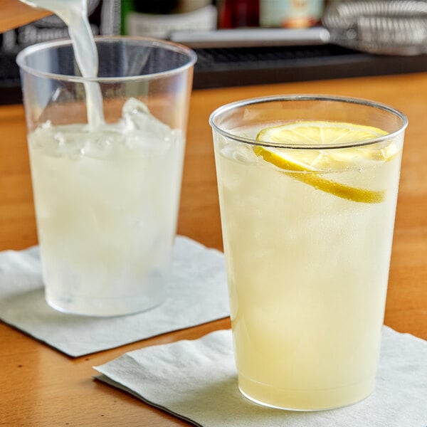 A clear Choice disposable plastic tumbler filled with lemonade, ice, and lemon slices.