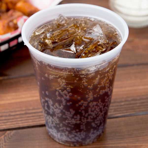 A Dart translucent plastic cup filled with a drink and ice with a straw.