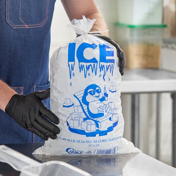 A clear plastic bag labeled 'ICE' and decorated with a cartoon penguin, filled with ice cubes.