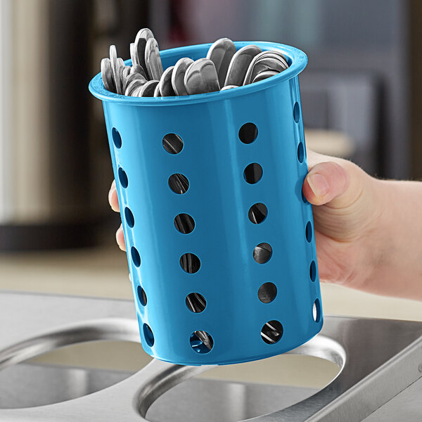 A hand holding a blue Steril-Sil flatware container filled with silverware.