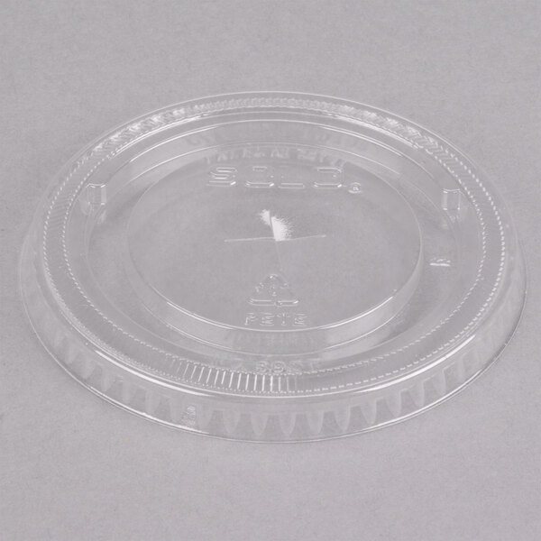 A clear Solo PET plastic lid with a straw slot over a small circle.