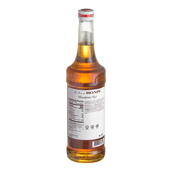 A Monin Premium Macadamia Nut flavoring syrup bottle with a white label.