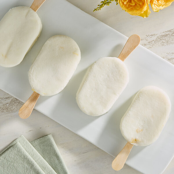 A white plate with Monin Coconut Fruit Puree popsicles on it.