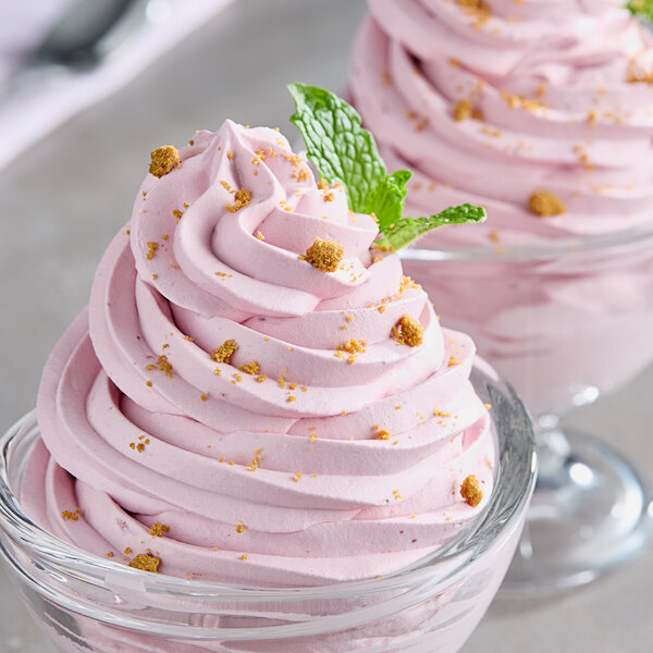 Two small bowls of pink Monin Wildberry Fruit Puree ice cream with sprinkles.
