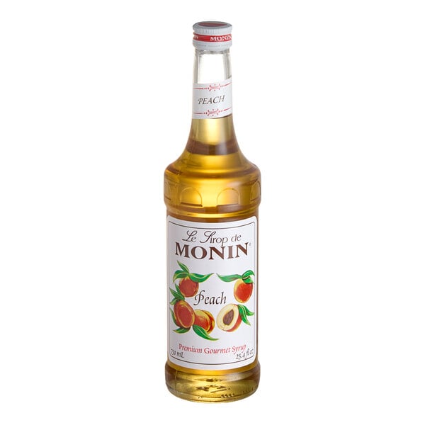 A bottle of Monin Peach Syrup with a white label.