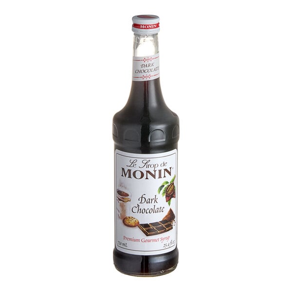 A bottle of Monin dark chocolate flavoring syrup with a white label.