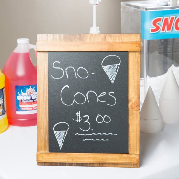 A Cal-Mil Madera chalkboard stand with white writing on it on a table.