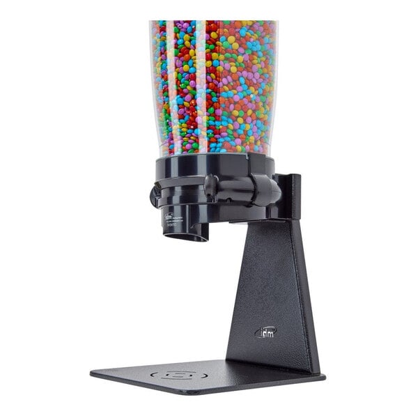 A black freestanding Cal-Mil tea leaf and topping dispenser with a round glass canister.