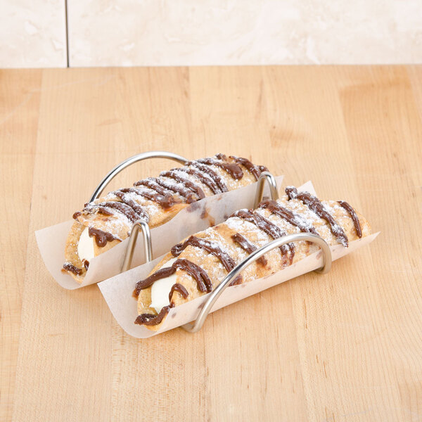 A pair of mini taco holders on a table with pastries in them.