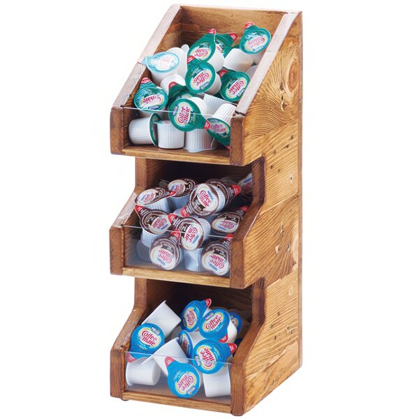 A wooden 3 tier Cal-Mil condiment display with clear bins holding coffee creamer and cups.