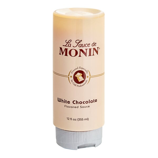 A white Monin bottle of White Chocolate Flavoring Sauce with a label.