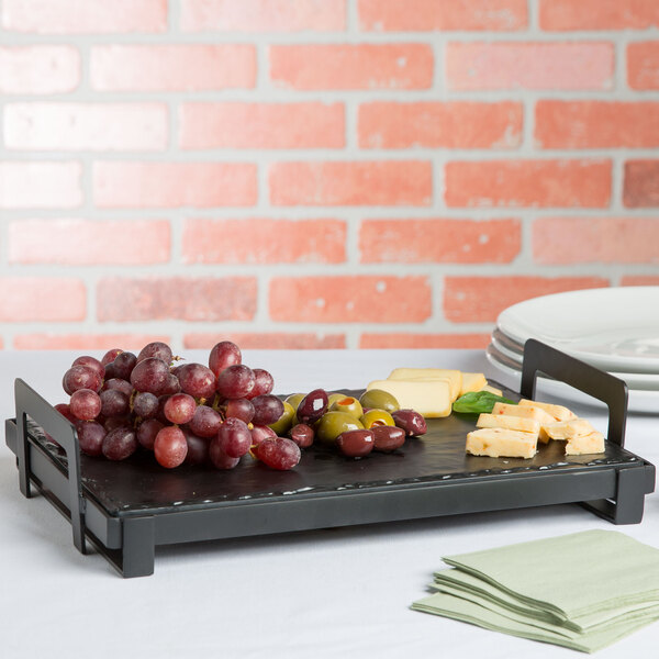 A black Cal-Mil rectangular melamine serving platter with grapes and cheese on it.