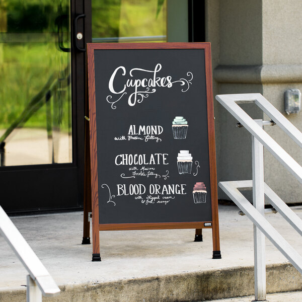 A cherry wood-look A-Frame chalkboard sign outside on the sidewalk.