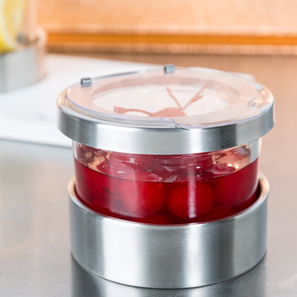 A Cal-Mil Luxe jar of red liquid with a hinged lid on a table.