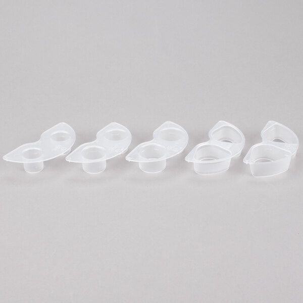 A white plastic container with six holes and six white plastic cups inside.