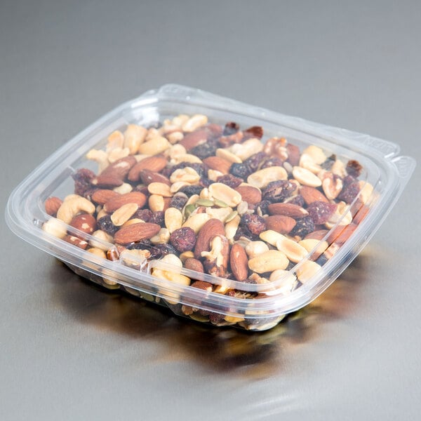 A Dart ClearPac plastic container filled with mixed nuts and seeds with a flat lid.