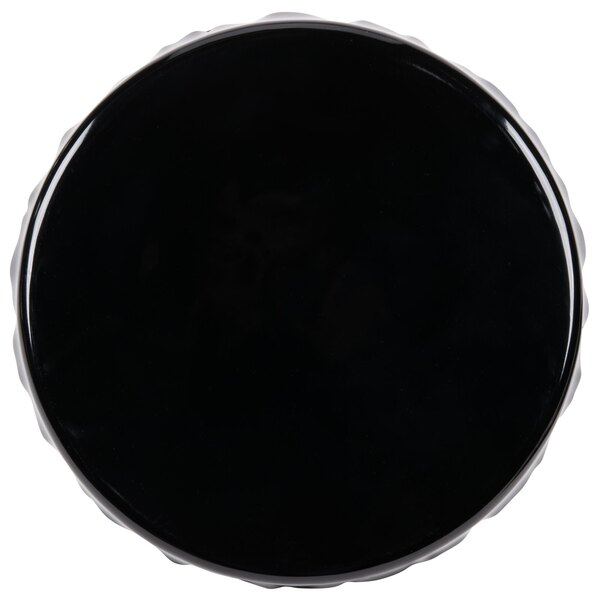 A black ruffled edge melamine cake stand on a white background.