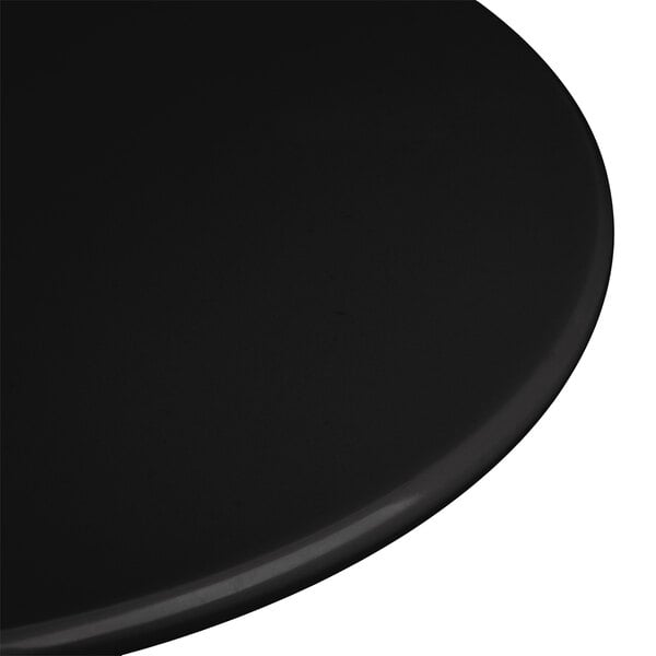 A close-up of a black Elite Global Solutions melamine plate on a black surface.