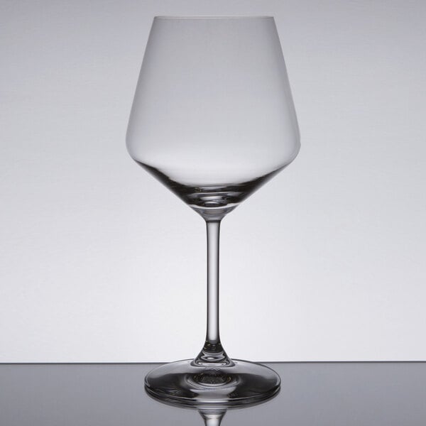 A clear Spiegelau Burgundy wine glass on a reflective surface.