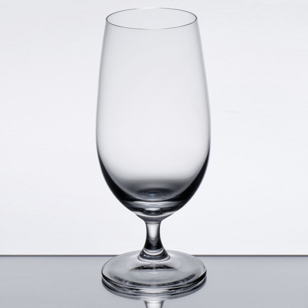 A clear Spiegelau stemmed Pilsner glass on a table.