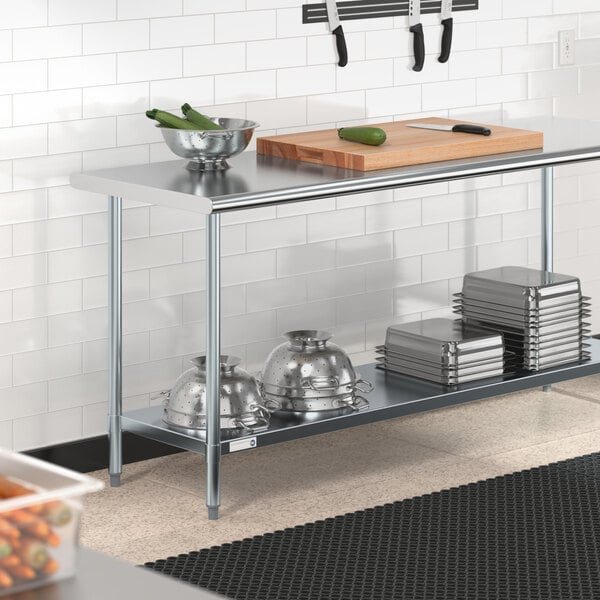 A Steelton stainless steel work table with a cutting board on an undershelf.