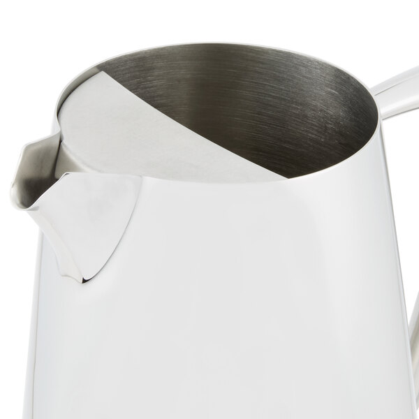 A Vollrath stainless steel water pitcher with a handle.
