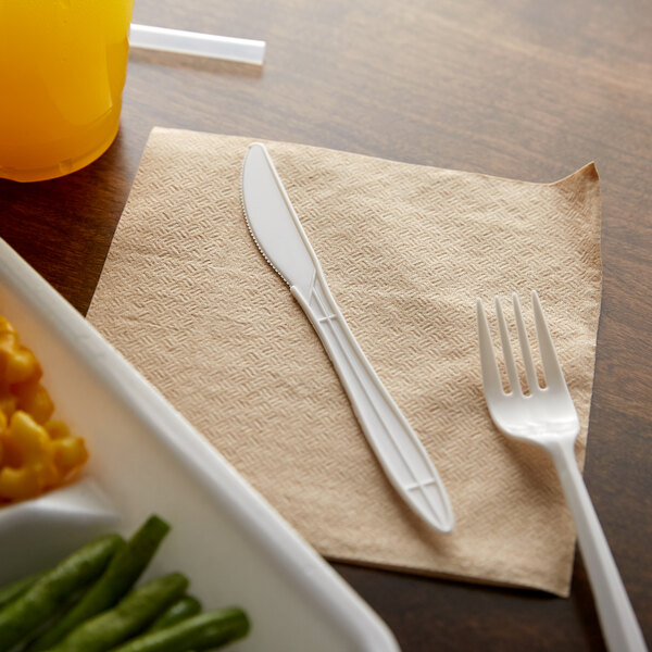 A white plastic knife on a beige napkin.
