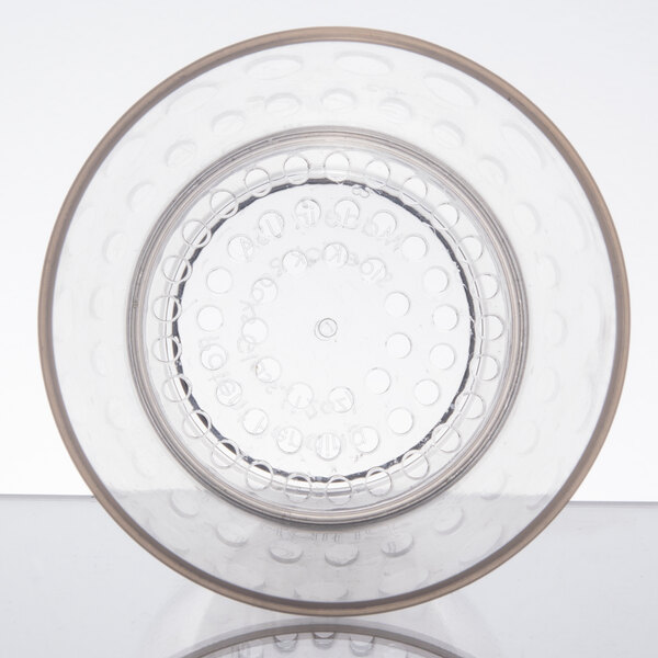 A clear plastic WNA Comet rocks glass with a circular pattern on top.