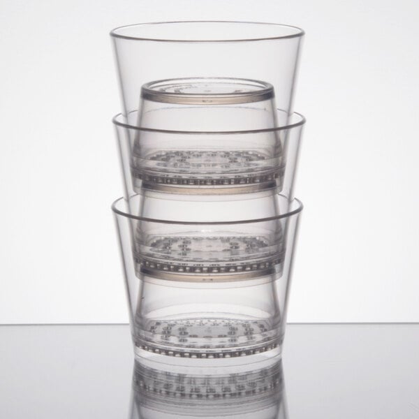 A stack of WNA Comet clear plastic rocks glasses.