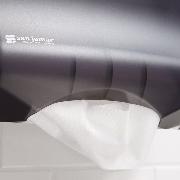 A white M-fold paper towel in a dispenser.