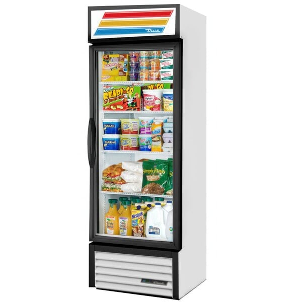 A white True refrigerated glass door merchandiser full of food including bread, candy, and beverages.