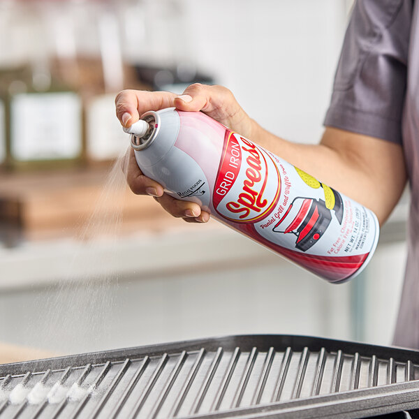 A can of Grid Iron Sprease 14 oz. Panini Grill and Waffle Iron Release Spray being used to coat a grill pan.