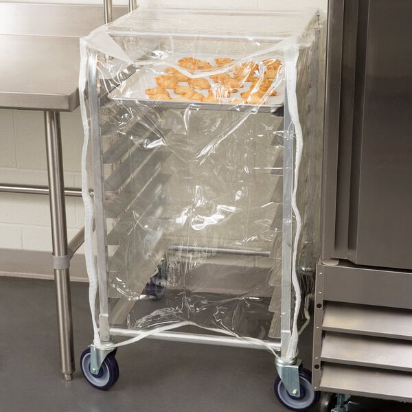 A Curtron clear plastic half size bun pan rack cover protecting a tray of doughnuts.