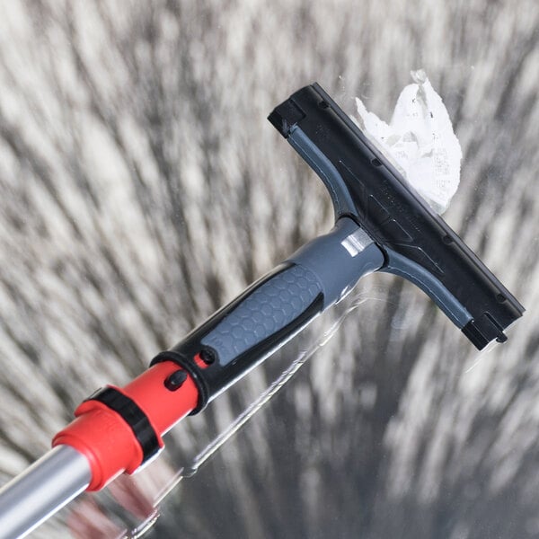 A black Unger ErgoTec Ninja window scraper with a safety cap.