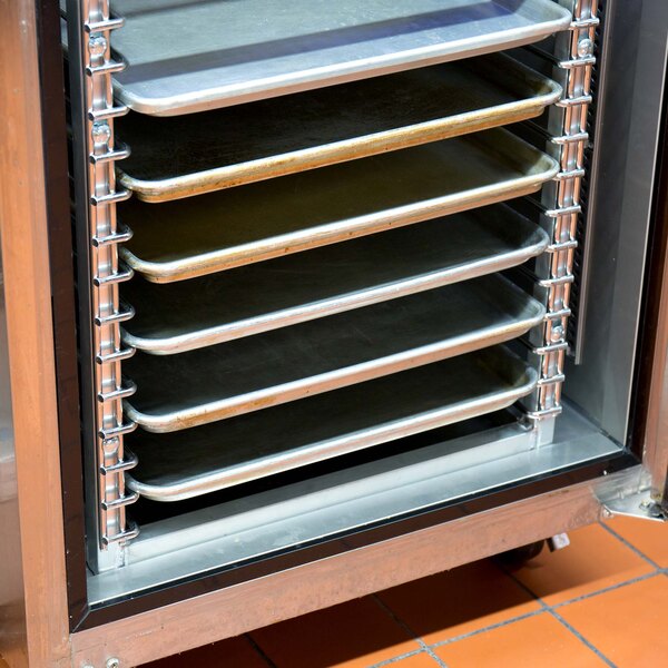 A Channel stainless steel end load sheet pan rack with trays inside.