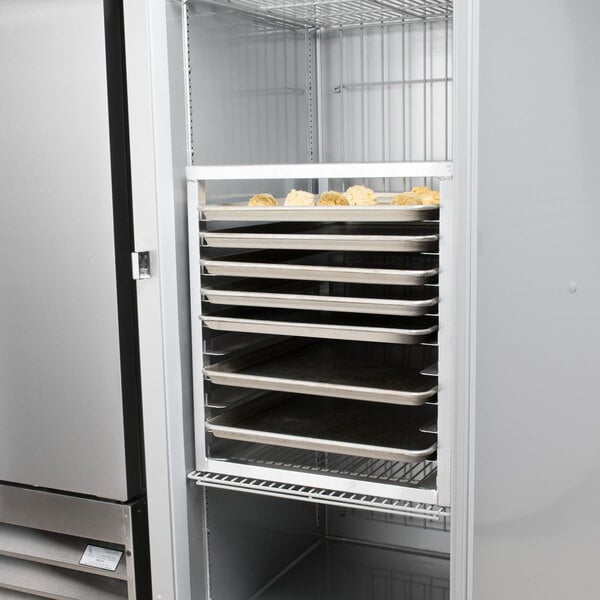 A Channel aluminum sheet pan rack with trays of food inside a refrigerator.