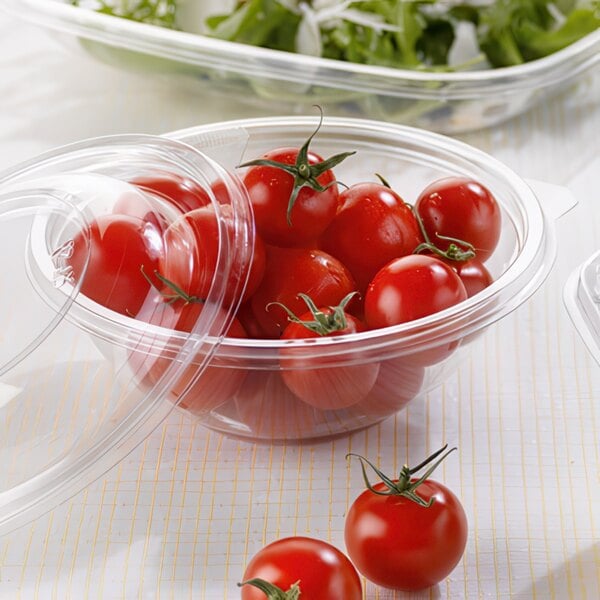 A Sabert clear plastic bowl filled with tomatoes and lettuce.