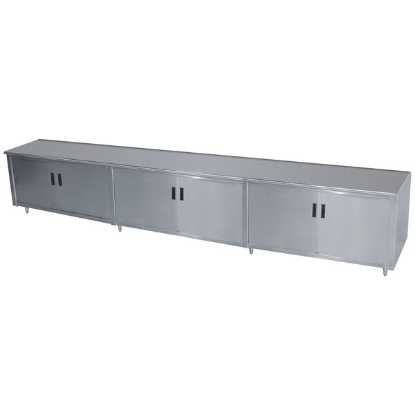 A stainless steel Advance Tabco enclosed base work table with hinged doors and a midshelf.