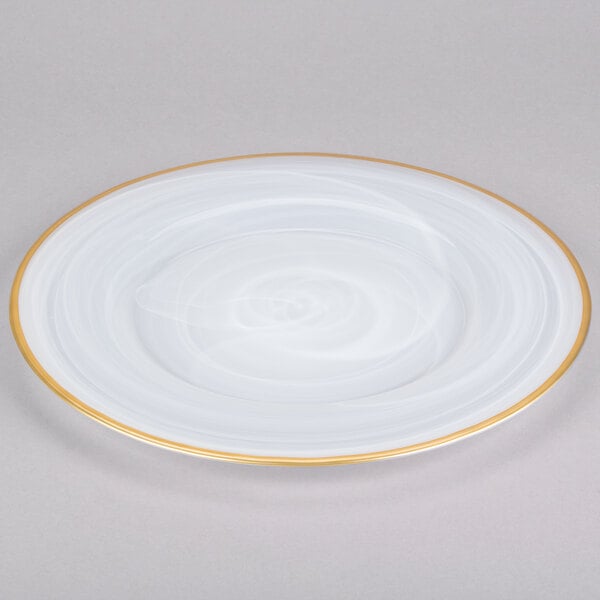 A white Charge It by Jay alabaster glass charger plate with a gold rim.