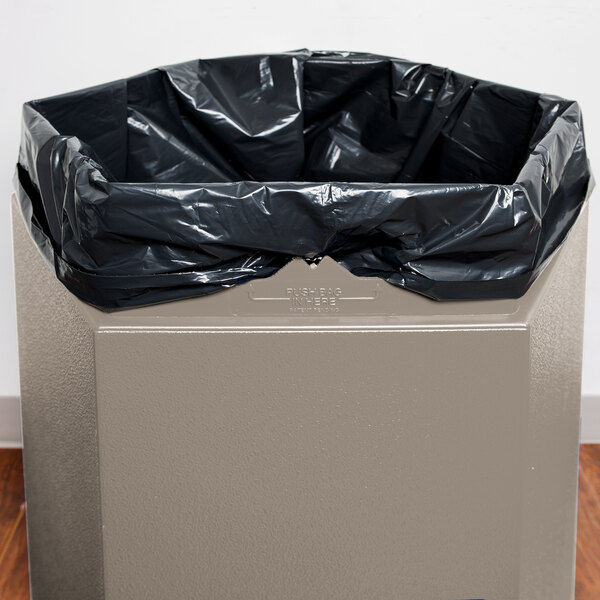 A beige hexagonal waste container with an open top.