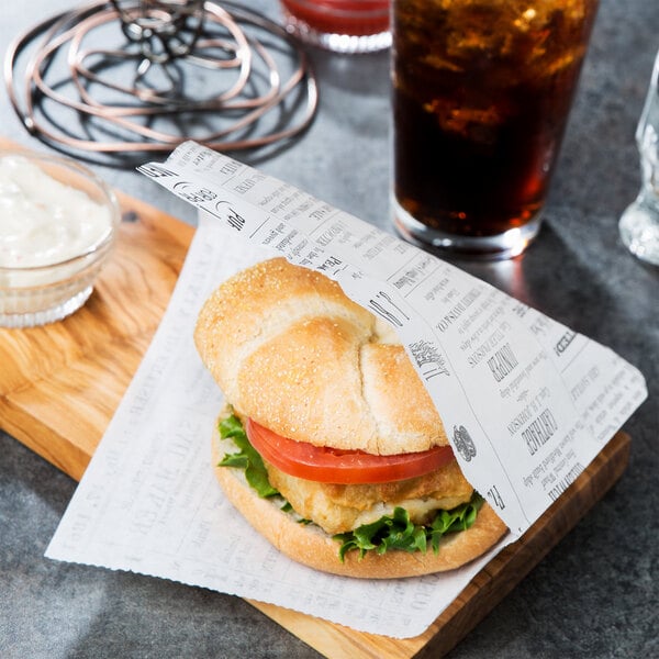 A burger wrapped in American Metalcraft newspaper print deli paper on a cutting board.