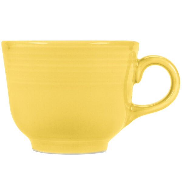 A yellow tea cup with a handle.