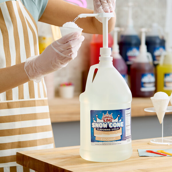 A large gallon jug of Carnival King coconut snow cone flavoring syrup with a pump dispenser.
