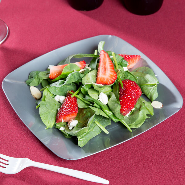 A Fineline silver square plastic salad plate with salad, strawberries, and spinach.