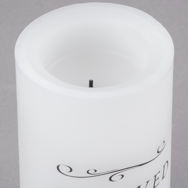 A white Sterno flameless wax pillar candle with black text that says "Reserved"