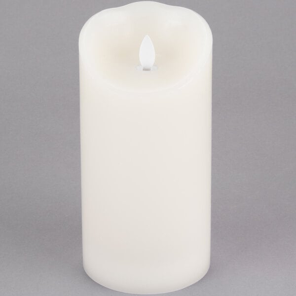 A Sterno cream LED candle with a flickering flame.