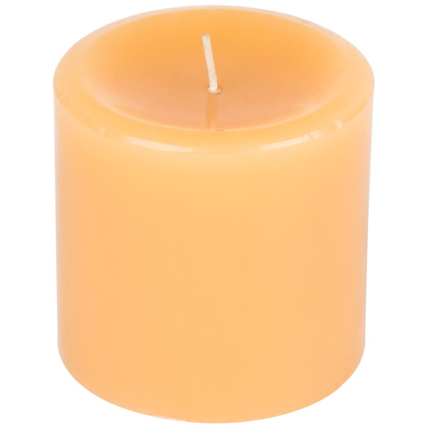A close up of a yellow Sterno beeswax pillar candle.