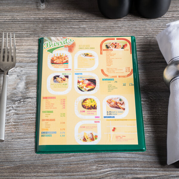 A Menu Solutions green menu board on a table with a fork and napkin.