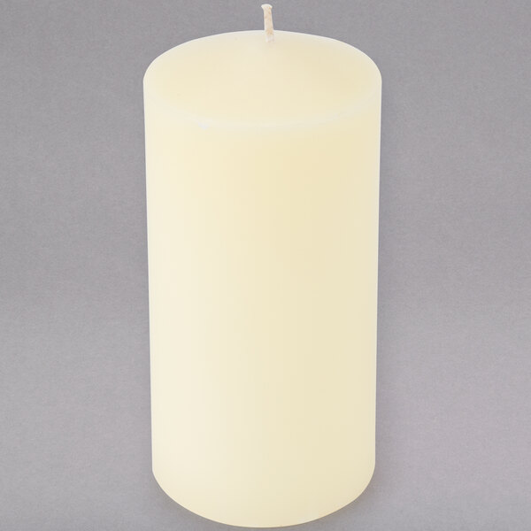 An ivory wax pillar candle on a white background.